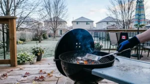 Grilling with Kingsford charcoal briquettes outdoors during chilly Canadian shoulder season weather.