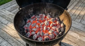 Glowing red hot charcoal briquettes under $30 CAD arranged evenly across a barbecue grill bed.